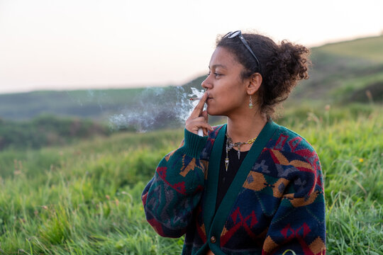 Woman smoking outdoors enjoying contemplative moment in nature