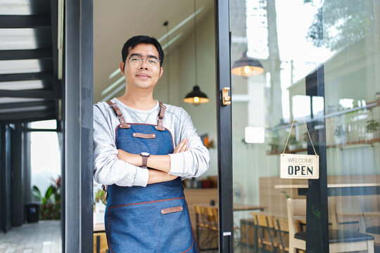 Small Business Owner Standing at Shop Entrance with Open Sign