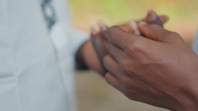 Romantic park engagement moment. Black couple shares emotional vow in scenic outdoor setting. Intimate outdoor scene where lovers exchange rings amidst natural surroundings and deep promises