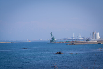 Obraz premium beautiful landscape of industrial factory , shinminato bridge an Japan alps background is amazing view at Amaharashi Coast Toyama Japan