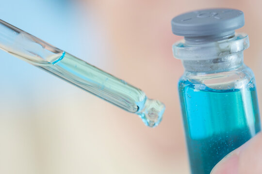 dropper with copper peptide serum ghk cu macro pipette glass vial liquid blue fluid substance cosmetic chemistry sample testing anti aging formulation clinical laboratory concept of biochemistry