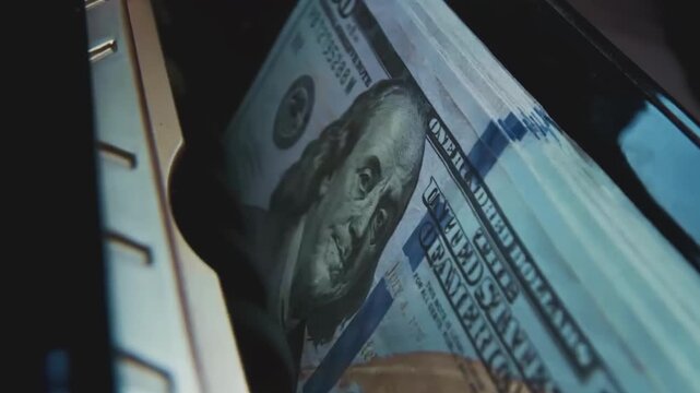 Money Counting Machine Processing Stack of 100 Dollar Bills in Banking Environment