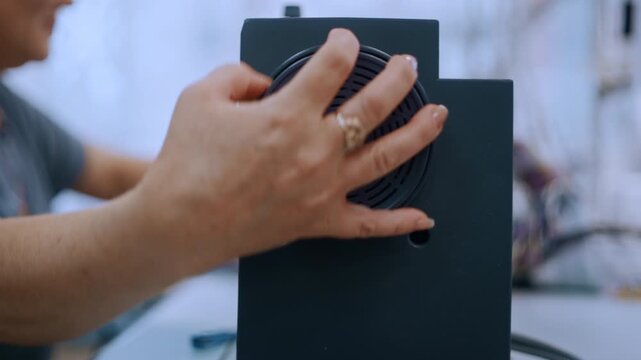 Close-up of a worker's hands adjusting an industrial sewing machine in a textile factory