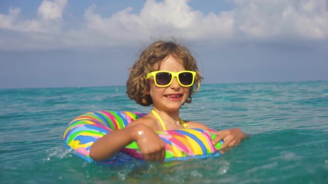 A happy child is having fun in the sea during the summer holidays. Slow motion