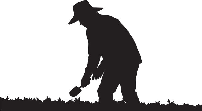 Black silhouette of man in hat digging with shovel in grass
