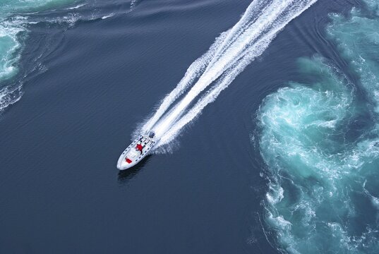 Powerboat between huge whirlpools and eddies in the water of a fjord, strongest tidal current in the world, Saltstraumen, Nordland, Kystriksveien, Bod&ouml;, Norway