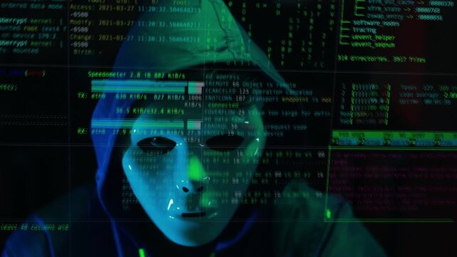 Masked hacker hacking computer. anonymous hacker wearing mask and black hoodie in dark room. online scam and cyber security threat.