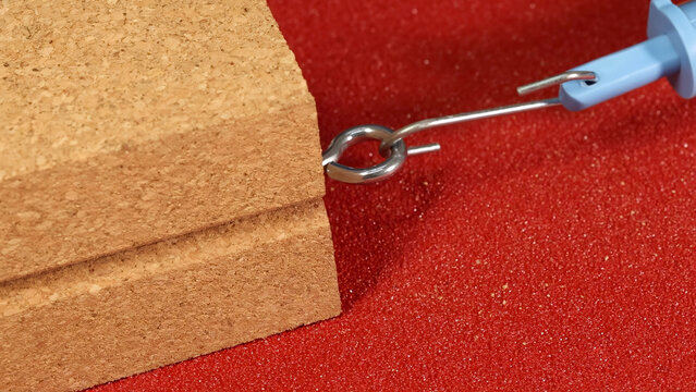 Close-up of Spring Scale Hook Attached to Wooden Block on Sandpaper