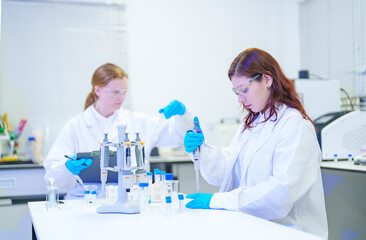 Fototapeta premium Scientists in a laboratory conducting research with pipettes and test tubes