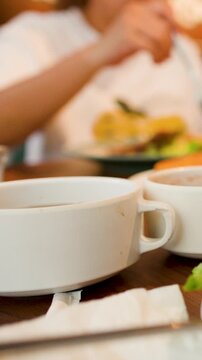 Close Up of White Soup Bowls on Table in Restaurant Setting