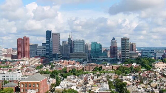 Aerial view of Baltimore skyline with historic church spire and urban architecture under cloudy sky.