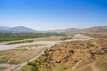 Fototapeta premium Mtkvari River cuts through the valley near Uplistsikhe ruins of Gori