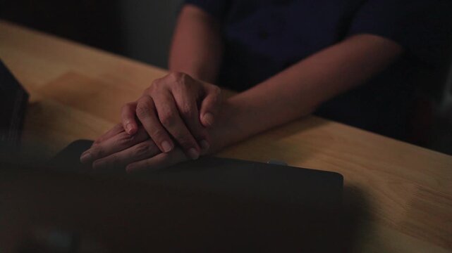 Waiting with Crossed Hands: A close-up shot of a person's hands clasped together, conveying a sense of anticipation, patience, or perhaps anxiety. The focus is on the gesture and the implied emotion.