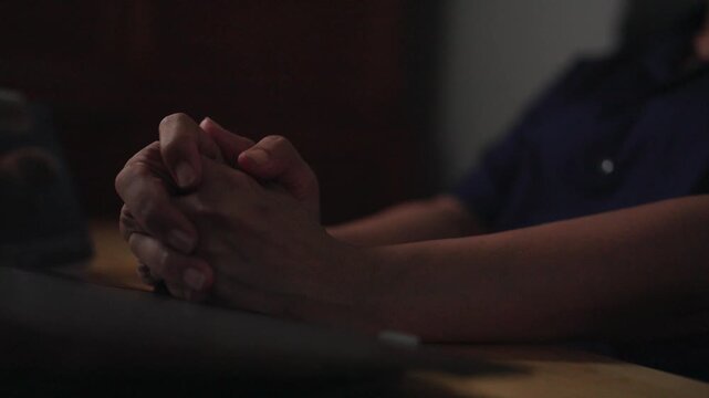 Prayerful Contemplation: Hands clasped in deep thought or prayer, conveying a sense of introspection, hope, or quiet desperation.