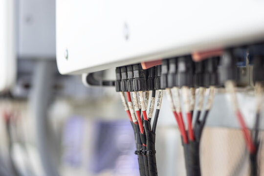 Close-up of MC4 connectors are connect into 10 MPPT string inverter or industrial solar inverter featuring 10 Maximum Power Point Trackers