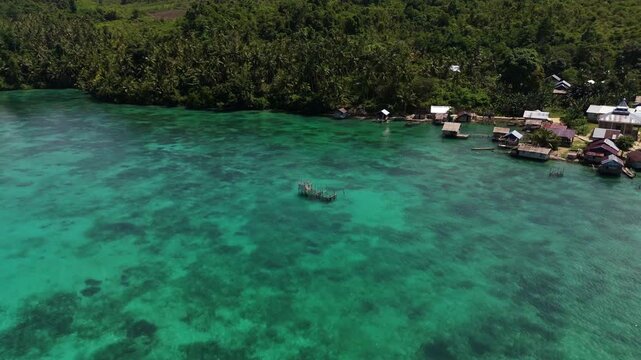 Breathtaking high angle panorama of untouched Banggai shoreline &ndash; Vivid turquoise water gradients, rugged coast and white sand in Sulawesi, clean cinematic background asset for advertising
