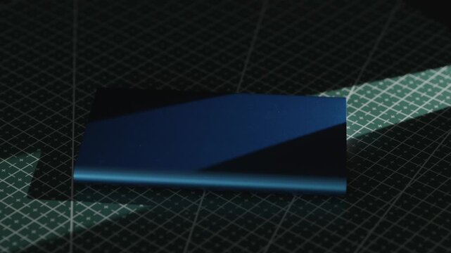 Placing external blue SSD drive on green leather desk mat