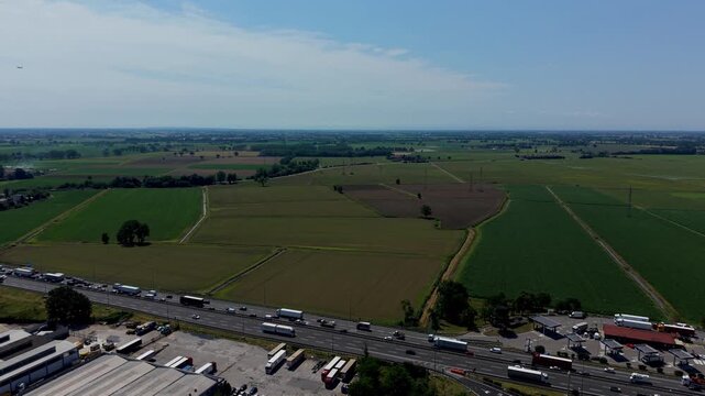 Aerial View of Traffic Congestion: An aerial perspective reveals a long line of trucks and vehicles stuck in traffic on a highway.
