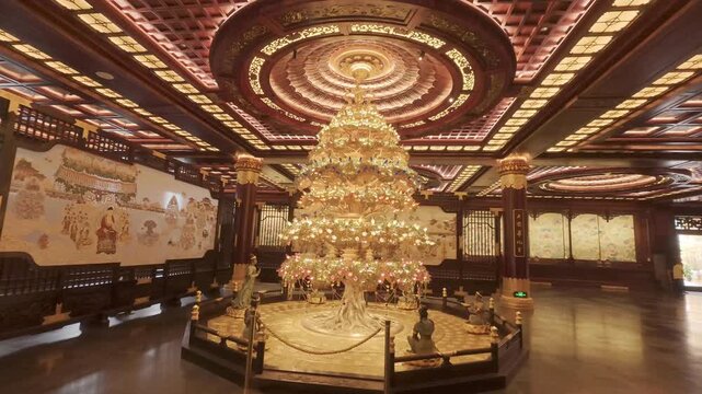 4K resolution cinematic pan right shot of a magnificent golden tree sculpture surrounded by Buddhist figures and exquisite murals inside the ornate main hall of Donglin Temple in Jiujiang, shot in Pro