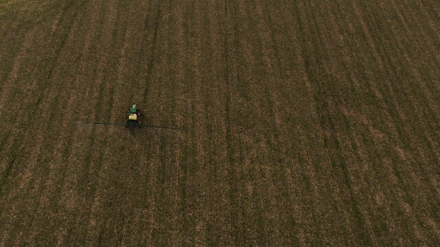 Trator trafegando por campos agr&iacute;colas de uma planta&ccedil;&atilde;o em Minas Gerais, Brasil, vista a&eacute;rea de cima.