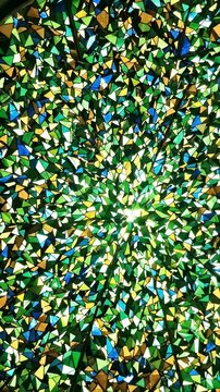 Green Kaleidoscope Pattern - A vibrant, abstract kaleidoscope pattern fills the frame with symmetrical green, yellow, and blue triangular shapes.