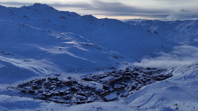 Aerial drone video Val Thorens dusk blue twilight cloud inversion mist winter French Alps Savoie 4K