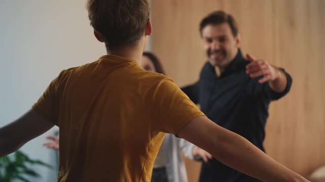 Smiling parents happy to see teen son coming home from college, family reunion