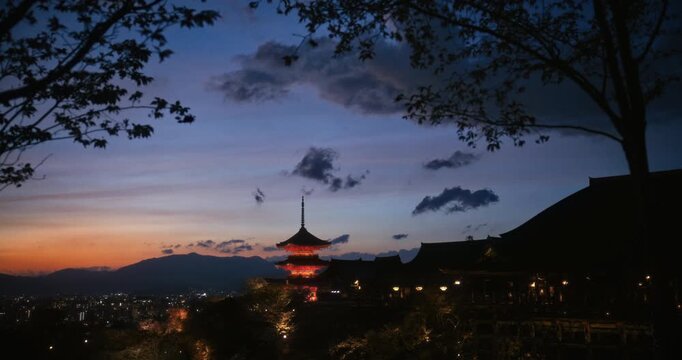 Cinematic view of glowing, ancient 8th century Japanese temple on hillside during the evening