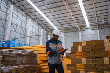 Fototapeta premium Black Factory Worker Using Digital Tablet in Cardboard Warehouse