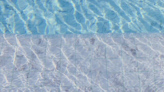 Ripped clear blue water in swimming pool.