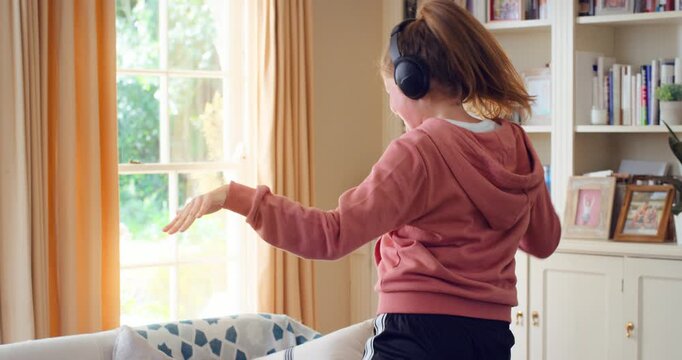 Dancing, happy and child with headphones in home for energy, practice and choreography. House, dancer and girl with music, audio and radio for movement, rhythm and streaming for hobby on weekend