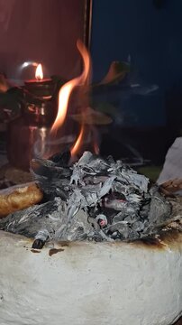 Traditional Sacred Fire Ritual with Glowing Embers and Oil Lamp