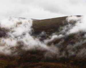 Obraz premium The tops of mountains are veiled by ethereal white mist.