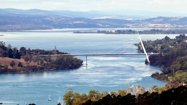 Traffic on Batman bridge across Tasman river in Tasmania &ndash; wine making region aerial landscape.