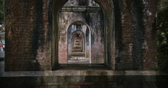 Tracking and dolly in shot on old brick arches under Japanese bridge