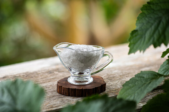 Borneol camphor crystal and Patchouli branch green leaves on natural background.