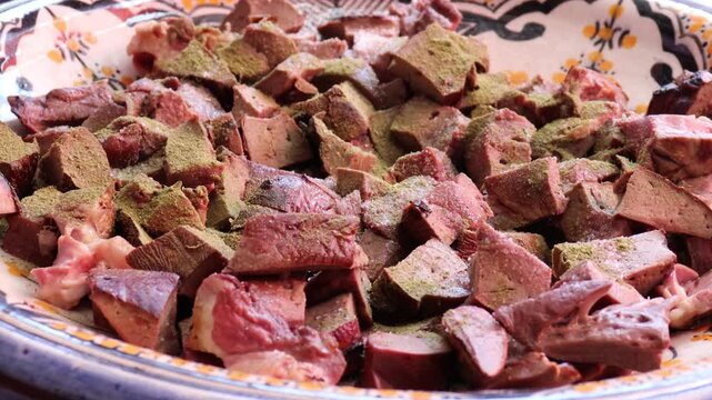 Seasoning lamb liver with spices for Moroccan boulfaf in pottery