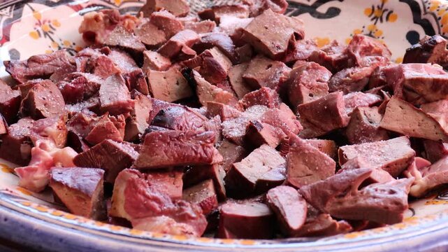 Seasoning lamb liver with spices for Moroccan boulfaf in pottery
