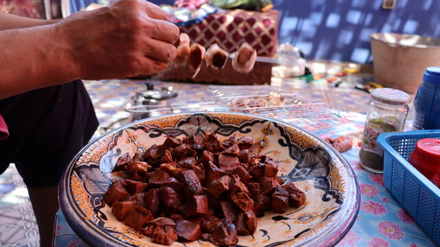 Threading boulfaf liver wrapped in caul fat on Moroccan skewer