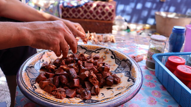 Threading boulfaf liver wrapped in caul fat on Moroccan skewer
