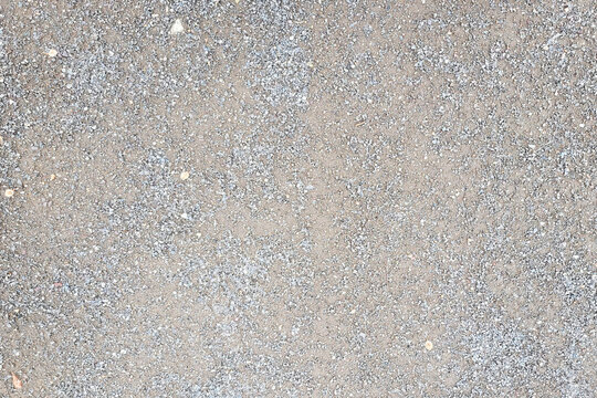 Seamless high angle texture of ground mixed with fine grey gravel stones and crushed sand, perfect as a natural abstract background or pattern for design work