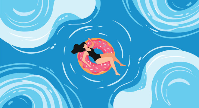 Top view of a young woman in a black swimsuit floating on a pink donut swim ring in swirling blue ocean water waves.