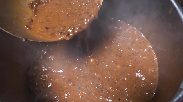 Close up shot of preparing Dal Makhani in traditional Indian dhaba kitchen.