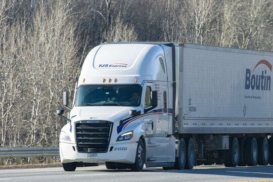 Quebec, Canada, 24 April 2026 : A white TJS Express semi-truck with a Boutin trailer drives on a highway