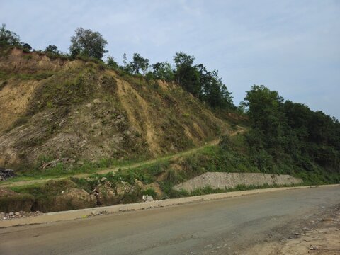 Vehicles traveling along a mountain highway toward Kathmandu, Nepal, through scenic Himalayan landscapes and rural settlements. Transportation, tourism, infrastructure, and regional connectivity