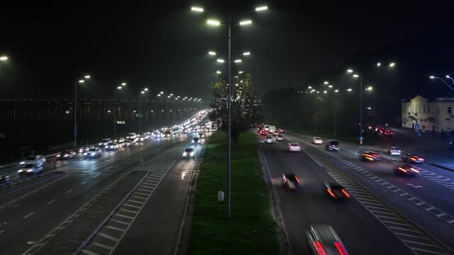 Timelapse of evening traffic in Kyiv's city center, cars moving with headlights on, speedlight