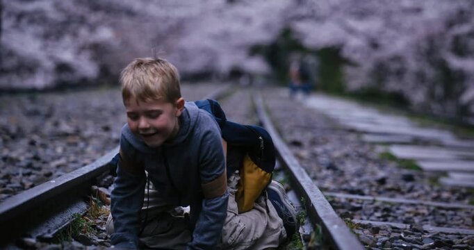Little boy crawling on old track and being silly