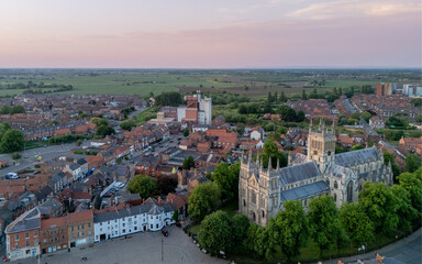 Fototapeta premium Selby Abbey in Selby, North Yorkshire, England, aerial view of the historic abbey, town centre rooftops, streets and medieval architecture.