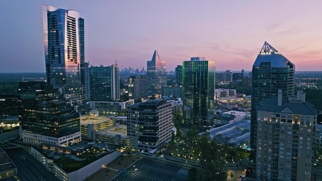 Aerial view of Buckhead Atlanta skyline at sunset with modern skyscrapers and vibrant city lights.