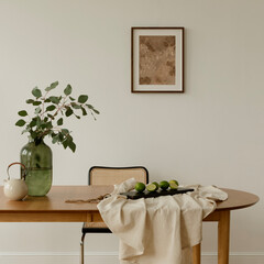 Minimalist dining room interior with a wooden table, green plant vase, limes, chair, and framed artwork on a white wall © FollowTheFlow